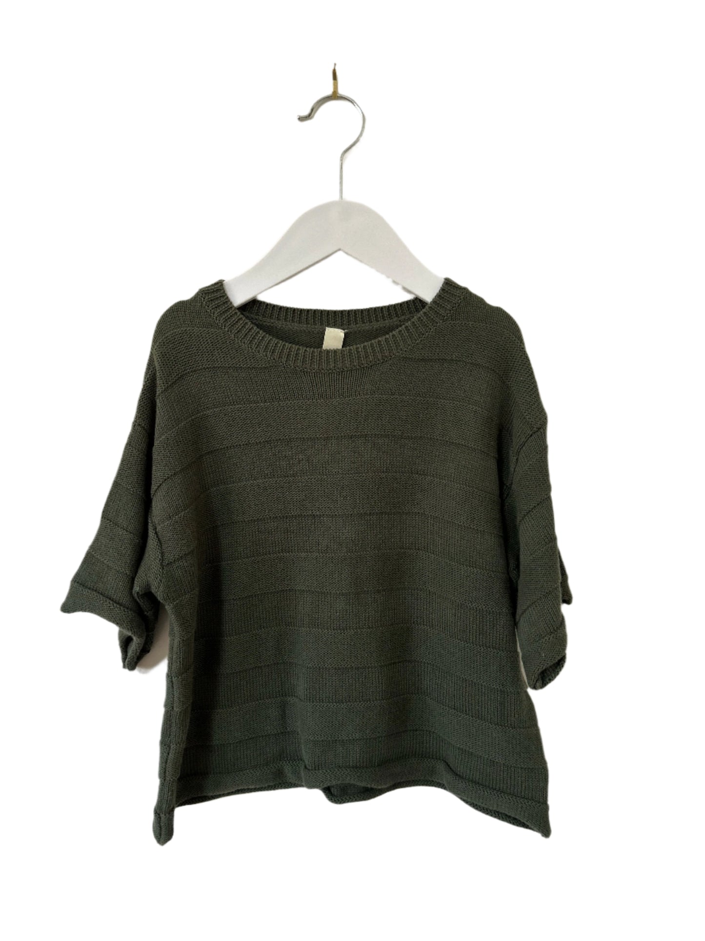 Green sweater on a hanger against a white background