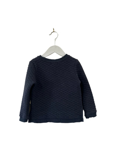 Navy blue textured sweater on a hanger against a plain background