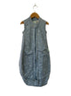 Blue sleeveless jacket with floral pattern on a hanger against a beige wall