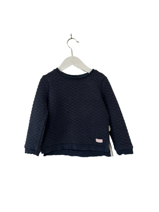 Navy blue textured sweater on a hanger against a white background