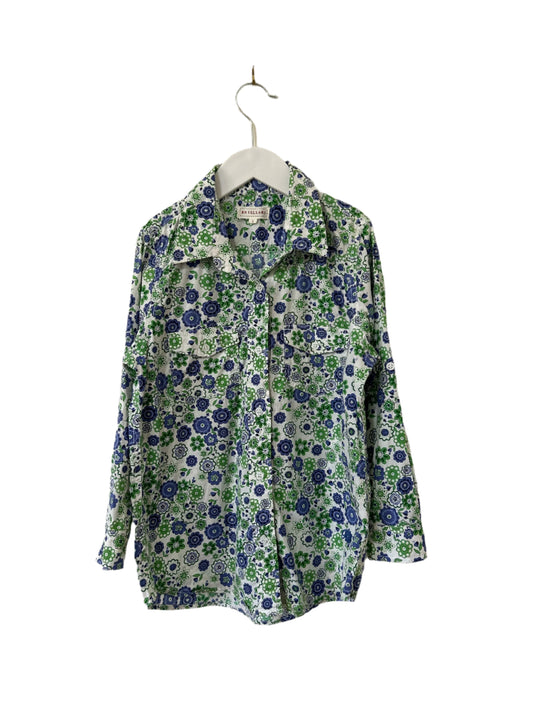 Floral patterned shirt on a hanger against a plain background