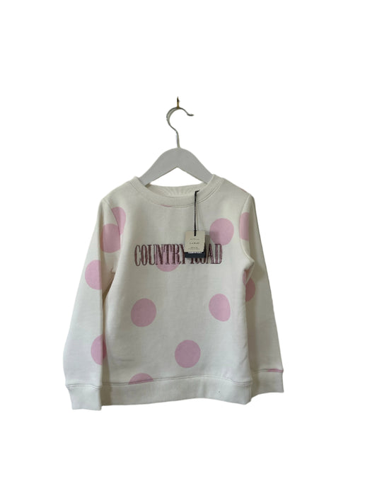 White sweatshirt with pink polka dots and 'COUNTRY GIRL' text on a hanger against a plain background